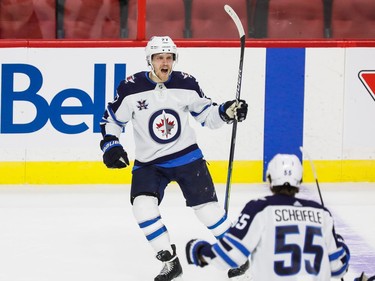 Jets centre Mark Scheifele heads over to congratulate teammate Nikolaj Ehlers after Ehlers scored the winning goal against the Senators in overtime on Tuesday night.