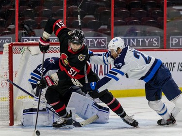 Senators centre Artem Anisimov (51) digs for a rebound against Jets centre Trevor Lewis in front of goaltender Laurent Brossoit in the third period on Tuesday night.