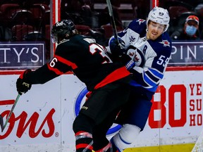 Senators centre Colin White checks Jets centre Mark Scheifele during third-period action.