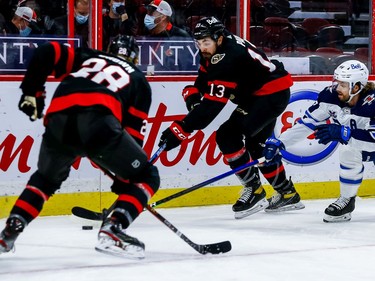 Senators left-winger Nick Paul passes the puck to right-winger Connor Brown as Jets defenceman Josh Morrissey defends during the first period.