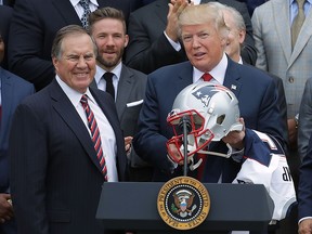 New England Patriots head coach Bill Belichick (left) presents a football helmet to President Donald Trump during a celebration of the team's Super Bowl victory at the White House April 19, 2017 in Washington.