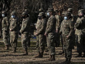 Members of the National Guard wear protective masks and stand in a formation on the U.S. Capitol grounds on January 22, 2021 in Washington.