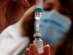 FILE: A healthcare worker prepares a dose of the Pfizer-BioNTech vaccine.