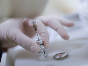 A health worker prepares an injection with a dose of the Pfizer-BioNTech COVID-19 vaccine.