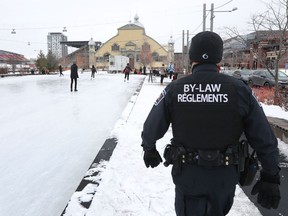 An Ottawa by-law officer checking for masks and numbers of skaters at Lansdowne Park in Ottawa, Tuesday Jan 5, 2021.