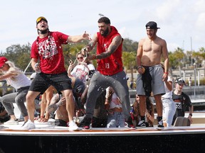 Members of the Tampa Bay Buccaneers celebrate with champagne during a boat parade to celebrate their victory in Super Bowl LV against the Kansas City Chiefs.