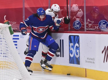 Alexander Romanov of the Canadiens and Alex Galchenyuk of the Senators battle along the boards for the puck during the first period.