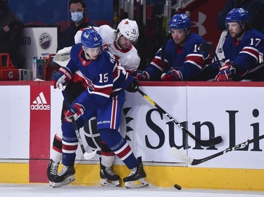 Jesperi Kotkaniemi of the Canadiens and Chris Tierney of the Senators battle for the puck against the boards during the first period.