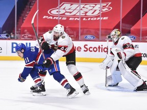Erik Gudbranson of the Ottawa Senators defends against Brendan Gallagher of the Montreal Canadiens near goaltender Matt Murray during the second period at the Bell Centre on February 4, 2021 in Montreal, Canada.