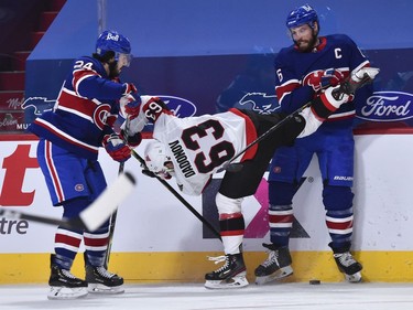 Canadiens players Phillip Danault, left, and Shea Weber put Senators forward Evgenii Dadonov in an awkward position during the third period.