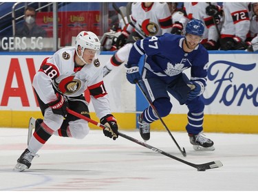 Tim Stutzle (left) of the Ottawa Senators skates with the puck against Pierre Engvall of the Toronto Maple Leafs during an NHL game at Scotiabank Arena on Monday in Toronto.