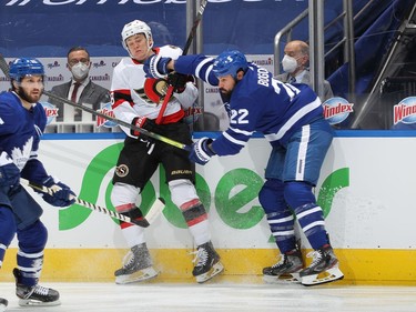 Tim Stutzle of the Ottawa Senators takes a hit from Zach Bogosian of the Toronto Maple Leafs during an NHL game at Scotiabank Arena on Monday in Toronto.