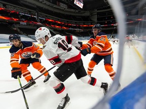 Edmonton Oilers' Tyson Barrie (22) and Darnell Nurse (25) battle Ottawa Senators' Tim Stutzle (18) during second period NHL action at Rogers Place in Edmonton, on Tuesday, Feb. 2, 2021.