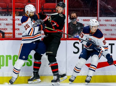 Senators left-winger Brady Tkachuk collides with Oilers defenceman Darnell Nurse as centre Ryan Nugent-Hopkins picks up the puck during the first period.