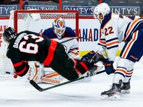 Oilers goaltender Mikko Koskinen makes a save on Senators right-winger Evgenii Dadonov as defenceman Tyson Barrie trips him in the first period.