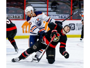 Senators left-winger Tim Stuetzle (18) is checked to the ice by Oilers defenceman Slater Koekkoek in the third period.