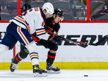 Senators left-winger Tim Stuetzle battles for the puck against Oilers defenceman Adam Larsson in the third period.