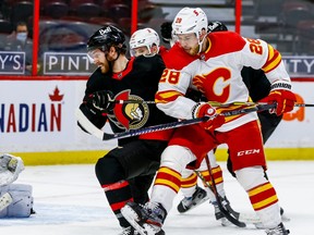 Senators’ Chris Tierney (left) battles with the Flames’ Elias Lindholm at the Canadian Tire Centre last night.