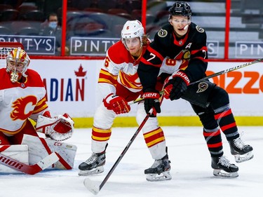 Ottawa Senators left wing Brady Tkachuk (right) battles for position with Calgary Flames defenceman Juuso Valimaki in front of Calgary Flames goaltender David Rittich.