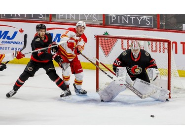 Ottawa Senators defenceman Artem Zub (left) checks Calgary Flames left wing Matthew Tkachuk in front of goaltender Matt Murray during first period action at the Canadian Tire Centre.