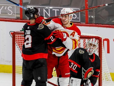 Ottawa Senators defenceman Artem Zub  checks Calgary Flames left wing Matthew Tkachuk in front of goaltender Matt Murray during first period on Thursday at the Canadian Tire Centre.