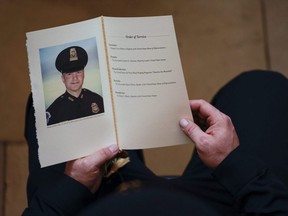 A U.S. Capitol police officer holds a program for the ceremony memorializing U.S. Capitol police officer Brian D. Sicknick, 42, as he lies in honour in the Rotunda of the Capitol in Washington D.C., on Feb. 3, 2021. Officer Sicknick died as a result of injuries he sustained during the Jan. 6 attack on the U.S. Capitol.