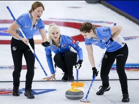 Team Quebec skip Laurie St-Georges makes a shot against Team Wild Card 1 as second Emily Riley, left, and lead Cynthia St-Georges sweep at the Scotties Tournament of Hearts in Calgary, Alta., Monday, Feb. 22, 2021.