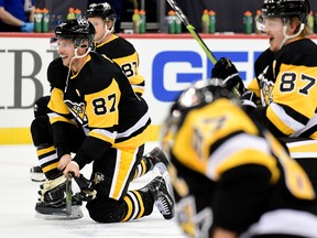 Penguins players take a knee and imitate Sidney Crosby's pre-game ritual of untying a skate and tying it back up to celebrate his 1,00th NHL game on Saturday.