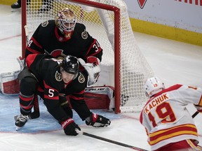 Ottawa Senators Joey Daccord watches defenceman Mike Reilly block a shot by Calgary Flames left wing Matthew Tkachuk in the third period at the Canadian Tire Centre on Saturday.