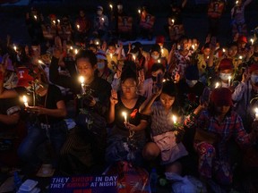 Protesters hold a candlelight vigil outside the U.S. Embassy during a demonstration against the military coup in Yangon on Feb. 21, 2021.