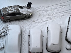 A man cleans his car from snow.