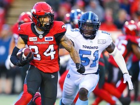 Calgary Stampeders Reggie Begelton takes off with the ball under pressure from Micah Awe of the Toronto Argonauts, July 18, 2019.