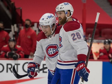 Canadiens centre Nick Suzuki (14) helps defenceman Jeff Petry (26) celebrate his first-period goal against the Senators celebrates a goal.
