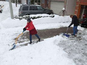 Dan Cameron and his wife Brenda clear the snow out of their driveway on Grandpark Circle in Ottawa Tuesday. Dan was one of about seven neighbours who got daytime winter parking ban tickets back in November. This was after the plow had already come by and he moved his vehicle onto the street so he could clear his driveway with a snowblower.