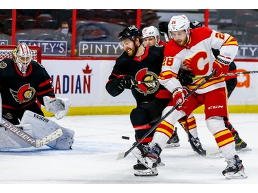 Ottawa Senators center Chris Tierney battles with Calgary Flames center Elias Lindholm in front of goaltender Matt Murray during the second period at the Canadian Tire Centre on Thursday.