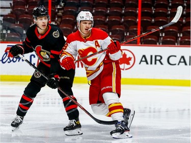 Ottawa Senators defenceman Mike Reilly checks Calgary Flames left wing Matthew Tkachuk during second period on Thursday.