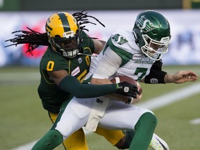 The Edmonton Eskimos' Don Unamba (left) battles the Saskatchewan Roughriders' quarterback Cody Fajardo during first half CFL action at Commonwealth Stadium in Edmonton Saturday Oct. 26, 2019.