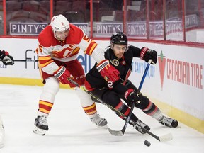 Artem Zub (right) of the Ottawa Senators battles for a loose puck against Mark Giordano of the Calgary Flames at Canadian Tire Centre on March 1, 2021 in Ottawa.