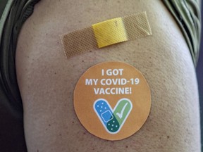 FILE: A band-aid and a sticker indicate that someone else has received their COVID-19 vaccine. Are you jealous?