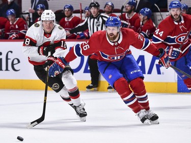 Tim Stuetzle of the Senators and Jeff Petry of the Canadiens skate after the puck during the first period.