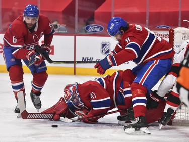 Canadiens goaltender Carey Price reaches to stop the puck as teammates Shea Weber, left, and Ben Chiarot defend the crease against the Senators during the first period.