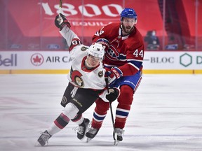 Tim Stuetzle of the Senators tries to squeeze past the Canadiens' Joel Edmundson during the first period of Tuesday's game in Montreal.