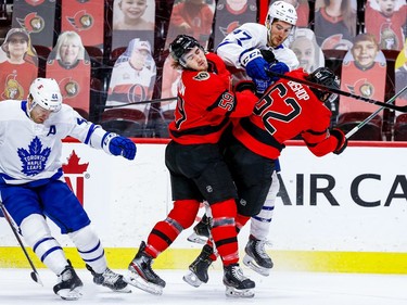 Senators left-winger Alex Formenton (59) and centre Clark Bishop (62) check Maple Leafs left-winger Pierre Engvall during the first period.