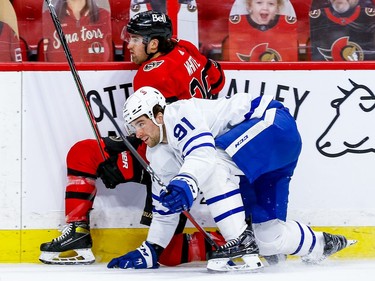 Senators centre Colin White gets hauled down by the Maple Leafs' John Tavares, who draws a penalty in the first period.