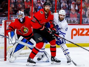 Senators goaltender Anton Forsberg seeks out the location of the puck while looking past teammate Braydon Coburn and the Maple Leafs' Alex Kerfoot in the second period.