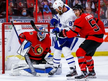 Senators goaltender Anton Forsberg makes a save as Maple Leafs forward Joe Thornton is checked by Alex Formenton during the second period.