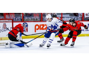 Senators defenceman Thomas Chabot and right-winger Evgenii Dadonov (63) try to hold up Maple Leafs winger Zach Hyman as he cuts toward the net of Anton Forsberg during the second period.
