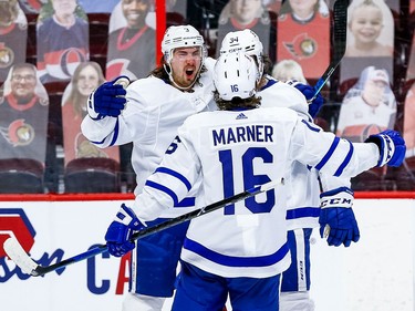 Maple Leafs defenceman Justin Holl, left, celebrates his overtime winning goal against the Senators with teammates Mitchell Marner and Auston Matthews.