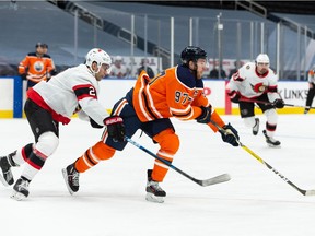 Edmonton Oilers' Connor McDavid (97) is chased by Ottawa Senators' Artem Zub (2) during third period NHL action at Rogers Place in Edmonton, on Friday, March 12, 2021.