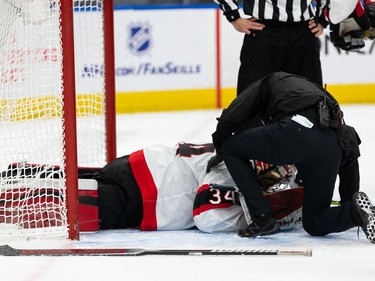 Ottawa Senators' goaltender Joey Daccord (34) is checked by medical staff after teammate Brady Tkachuk (7) shoved EDMONTON Oilers' Gaetan Haas (91) into his net during third period NHL action at Rogers Place in Edmonton, on Friday, March 12, 2021.
